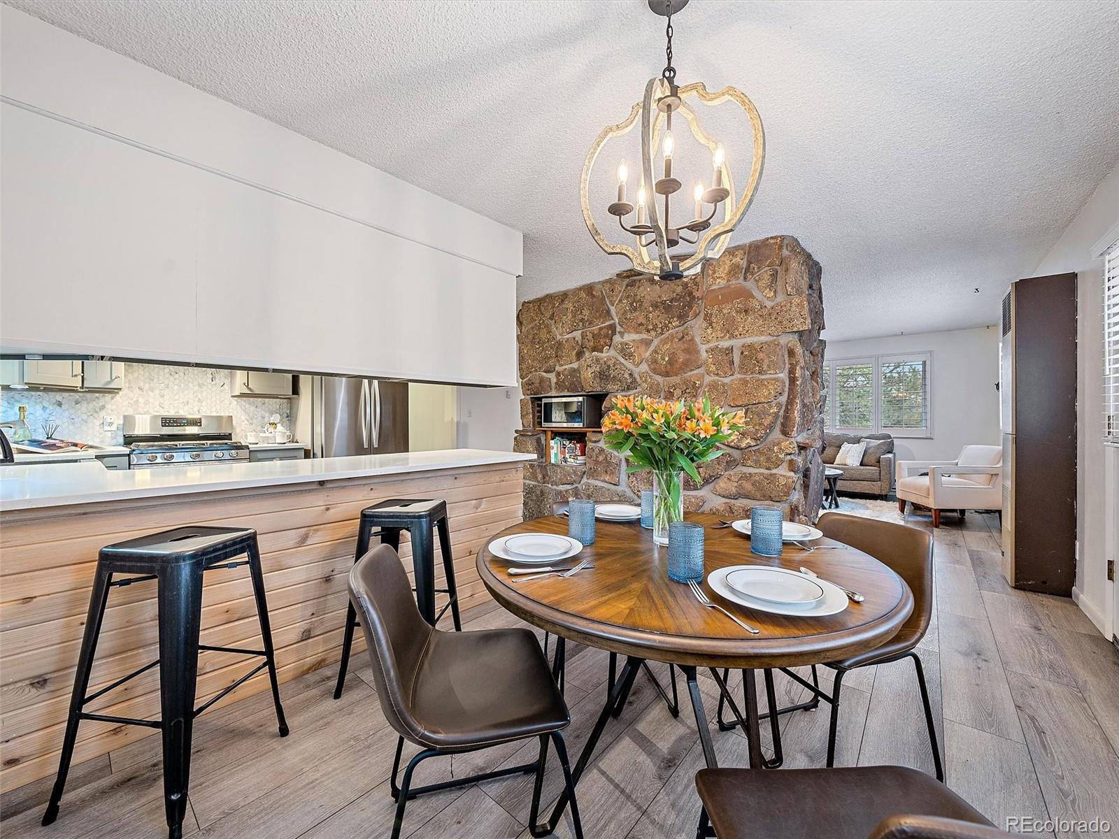 27422 Pine Valley Drive Evergreen, CO 80439 - Photo 7 of 42 a view of a dining room with furniture a chandelier and wooden floor
