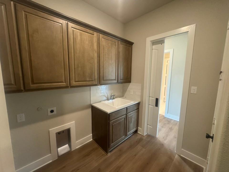 412 Indian Crk Road Van Alstyne, TX 75495 - Photo 17 of 24 a view of a utility room with wooden floor and cabinet