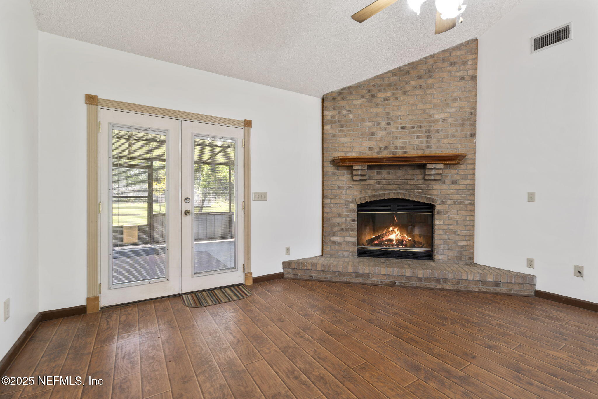54230 Heller Road Callahan, FL 32011 - Photo 11 of 37 an empty room with wooden floor fireplace and windows