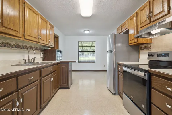 a kitchen with stainless steel appliances granite countertop a stove a sink and a refrigerator