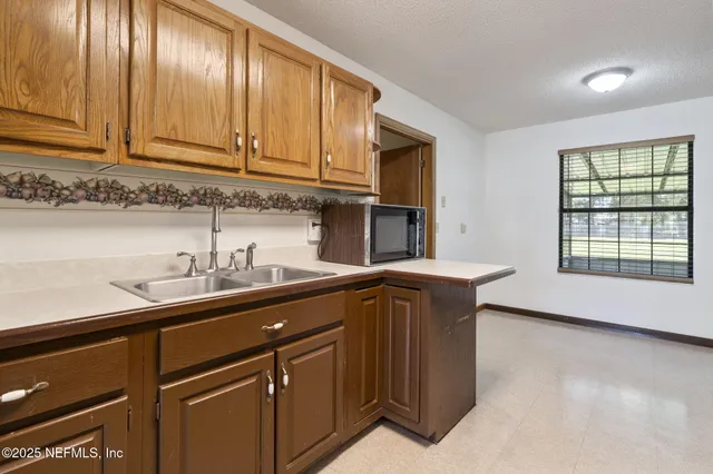 a kitchen with stainless steel appliances granite countertop a sink a stove and a microwave oven