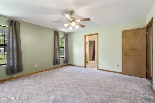 an empty room with closet and a chandelier fan