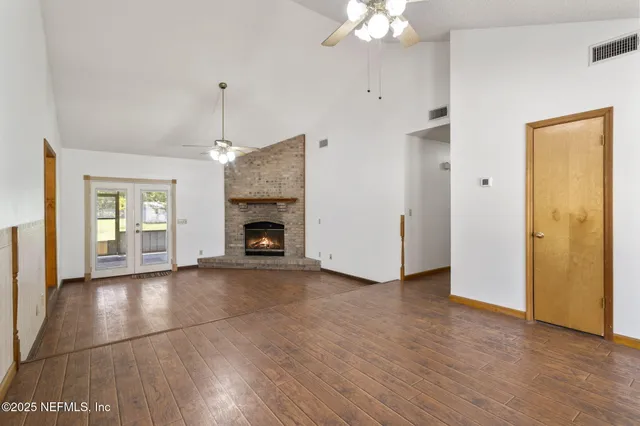 a view of empty room with wooden floor and fireplace