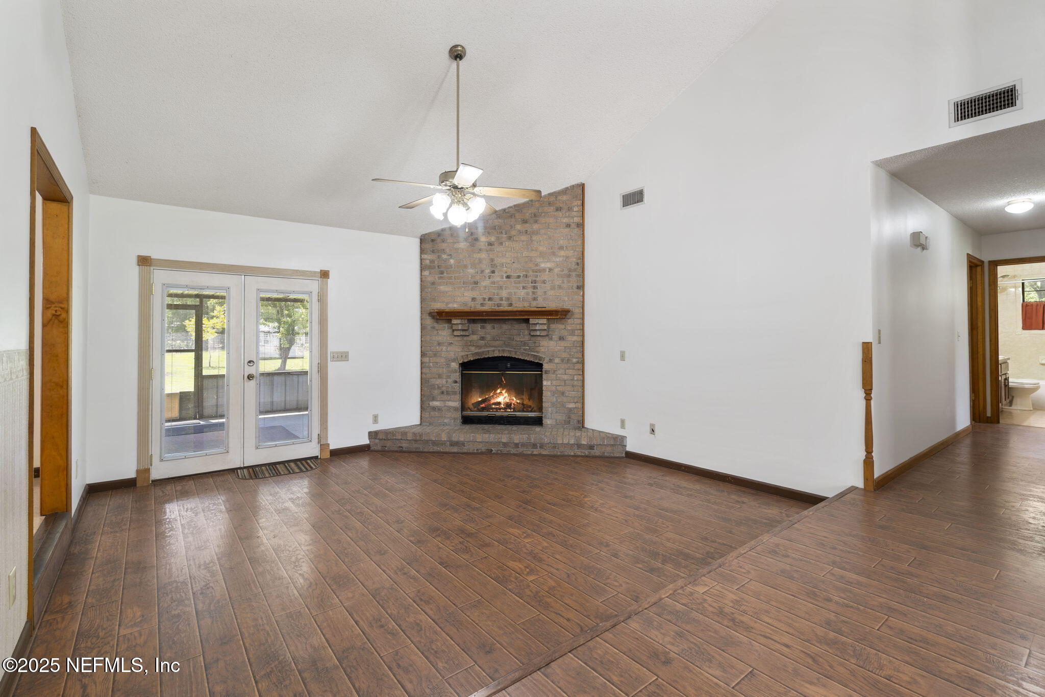 54230 Heller Road Callahan, FL 32011 - Photo 9 of 37 a view of an empty room with wooden floor and a fireplace