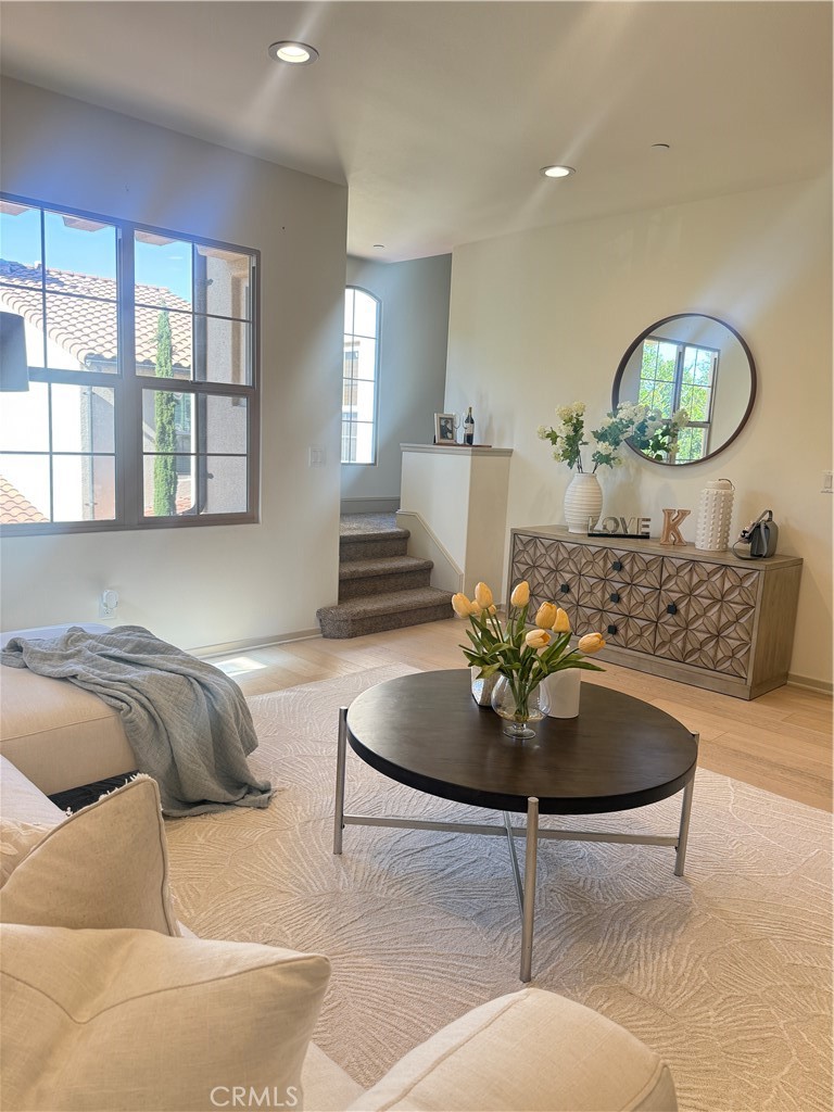 87 Evening Sun Irvine, CA 92620 - Photo 12 of 29 a living room with furniture a chandelier and a large window