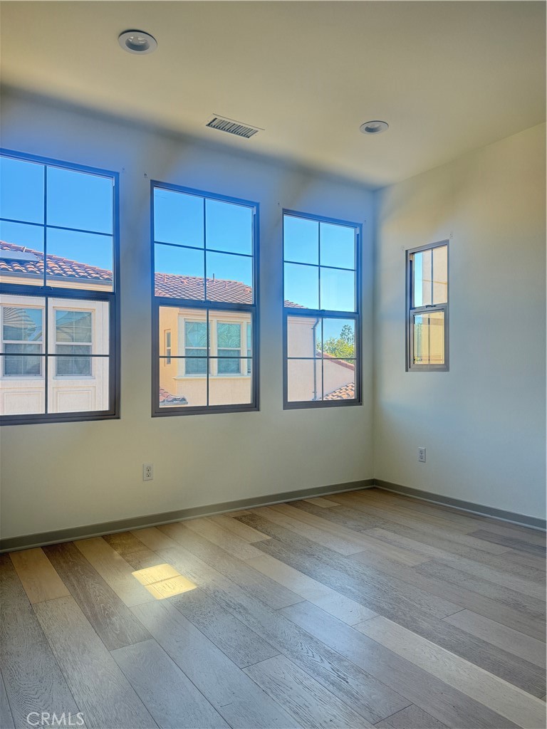 87 Evening Sun Irvine, CA 92620 - Photo 23 of 29 an empty room with wooden floor and windows