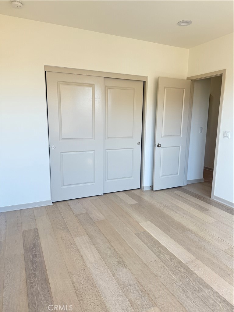 87 Evening Sun Irvine, CA 92620 - Photo 24 of 29 a view of an empty room with wooden floor and closet