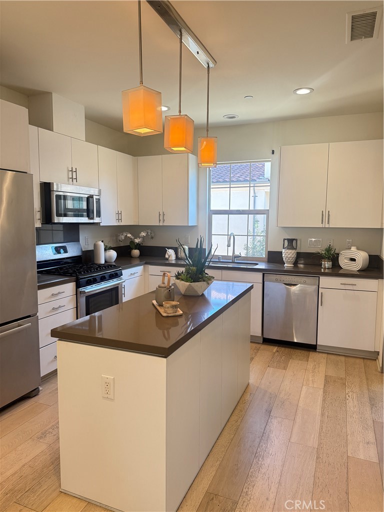 87 Evening Sun Irvine, CA 92620 - Photo 8 of 29 a kitchen with stainless steel appliances granite countertop a sink a stove and refrigerator