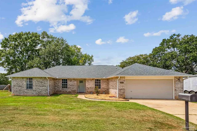 a front view of a house with a garden and yard