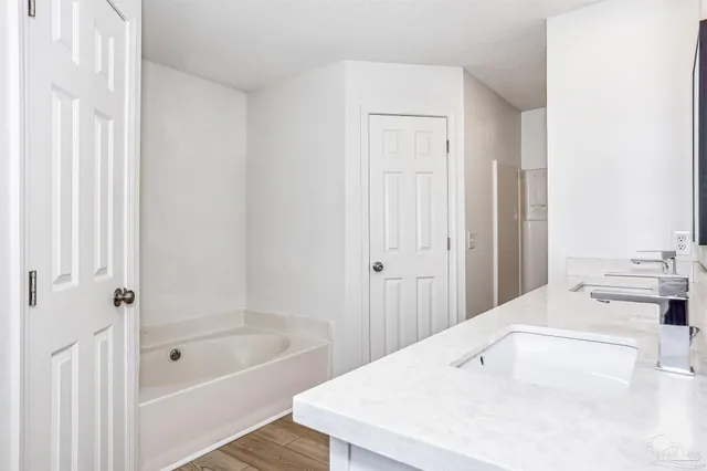 a bathroom with a tub a sink and a window