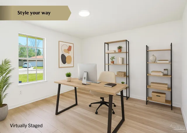 a view of a workspace with furniture and a window