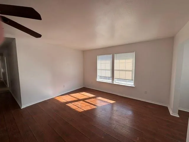 a view of a room with wooden floor and windows