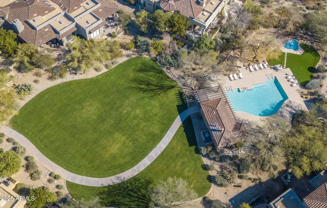 a view of a patio with dining table and chairs with plants and wooden fence
