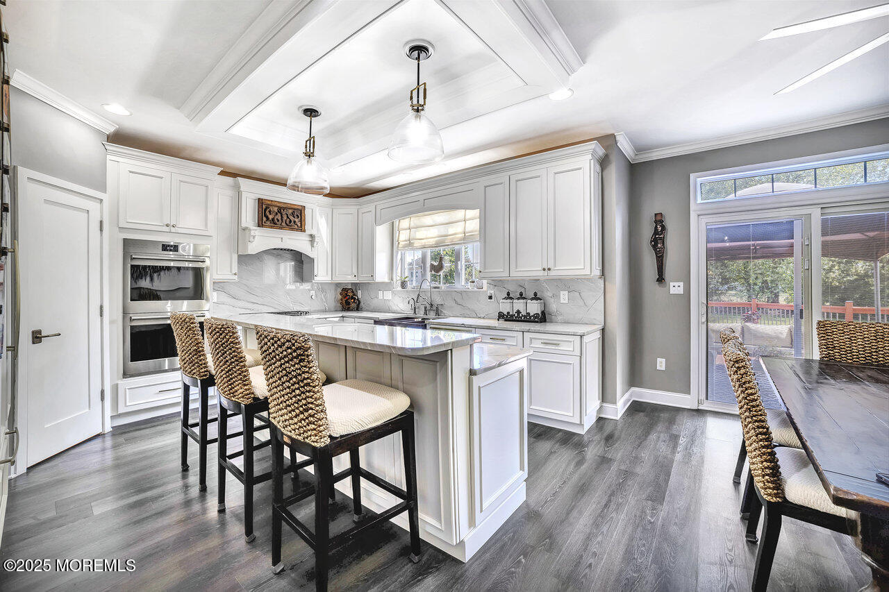 11 Victoria Court Cream Ridge, NJ 08514 - Photo 14 of 67 a kitchen with stainless steel appliances granite countertop a stove a refrigerator a microwave oven a dining table and chairs with wooden floor