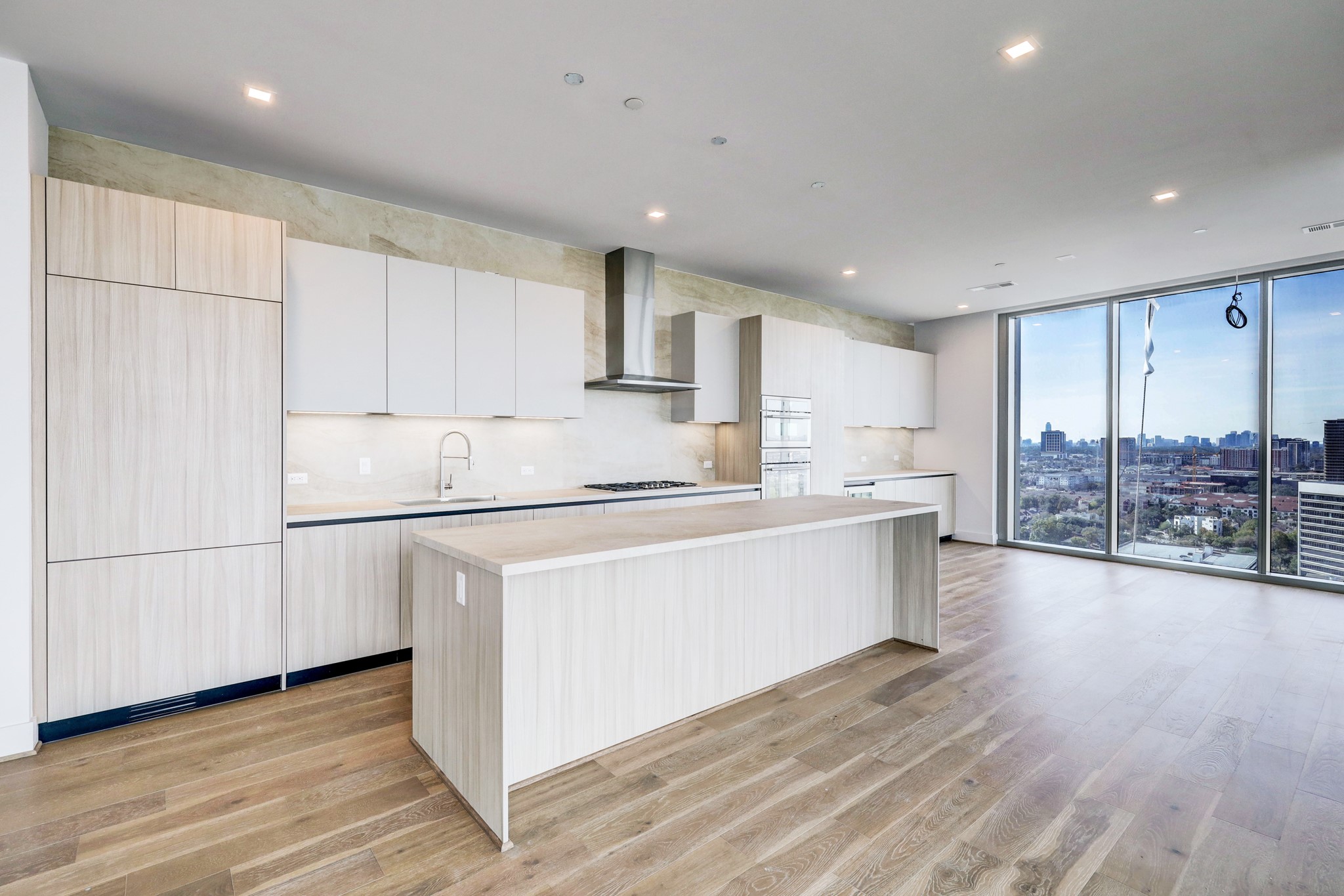 The kitchen features Pedini Italian  cabinetry, a spacious island, and Thermador appliances.  Offered is an  open layout with large floor-to-ceiling windows offering stunning panoramic city and  bayou views perfect for natural light and entertaining.