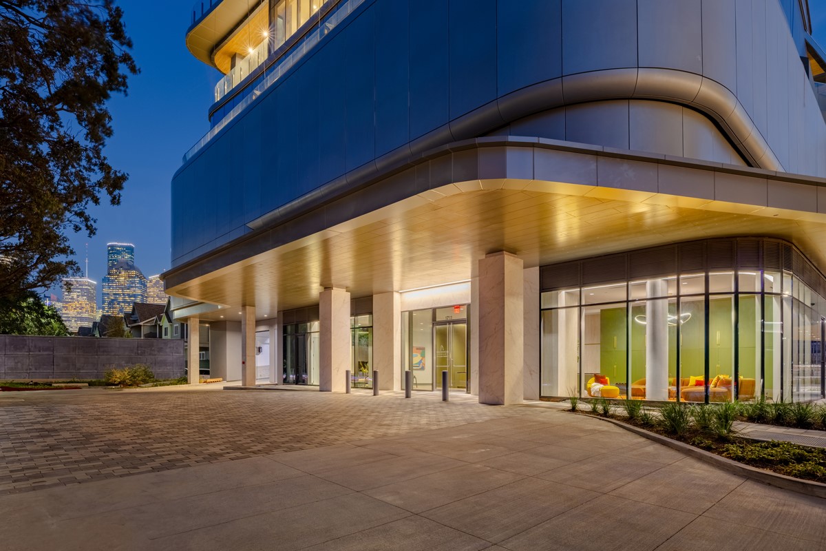 1711 Allen Parkway, Unit 2001 Houston, TX 77019 - Photo 16 of 33 The Residences at The Allen, Houston’s premiere Luxury Condo Hotel Tower on Allen Parkway, Houston, stands gracefully against the city skyline. Its modern design and glass windows exude sophistication, while a warm glow from the setting sun highlights its elegance. Private balconies with lush greenery offer panoramic views of downtown Houston and Buffalo Bayou Park. This building embodies luxury living, with exceptional amenities and breathtaking vistas.