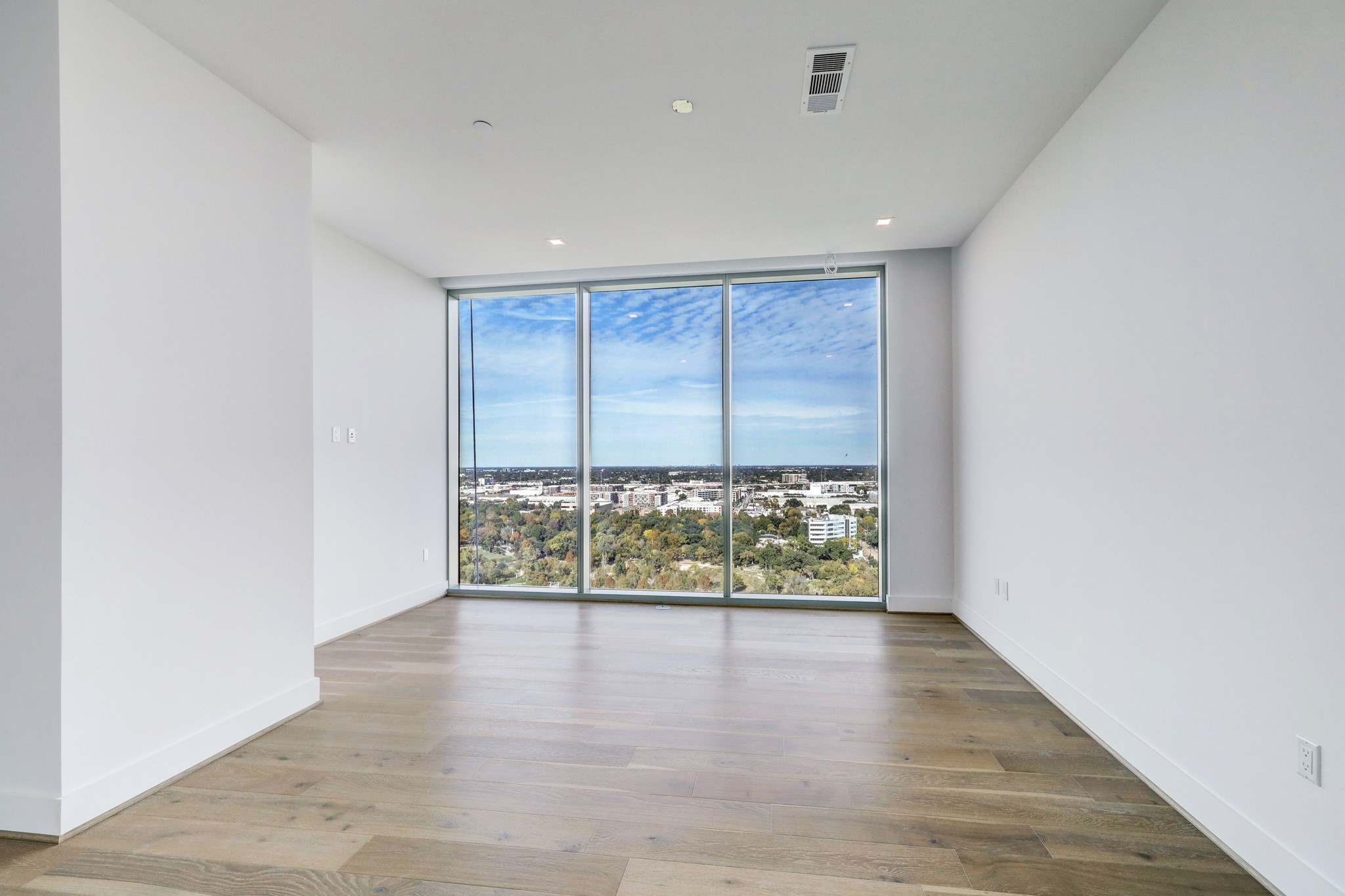 1711 Allen Parkway, Unit 2001 Houston, TX 77019 - Photo 4 of 33 Bright, spacious primary bedroom with engineered hard wood floors, sitting area, floor-to-ceiling windows and protected bayou views.