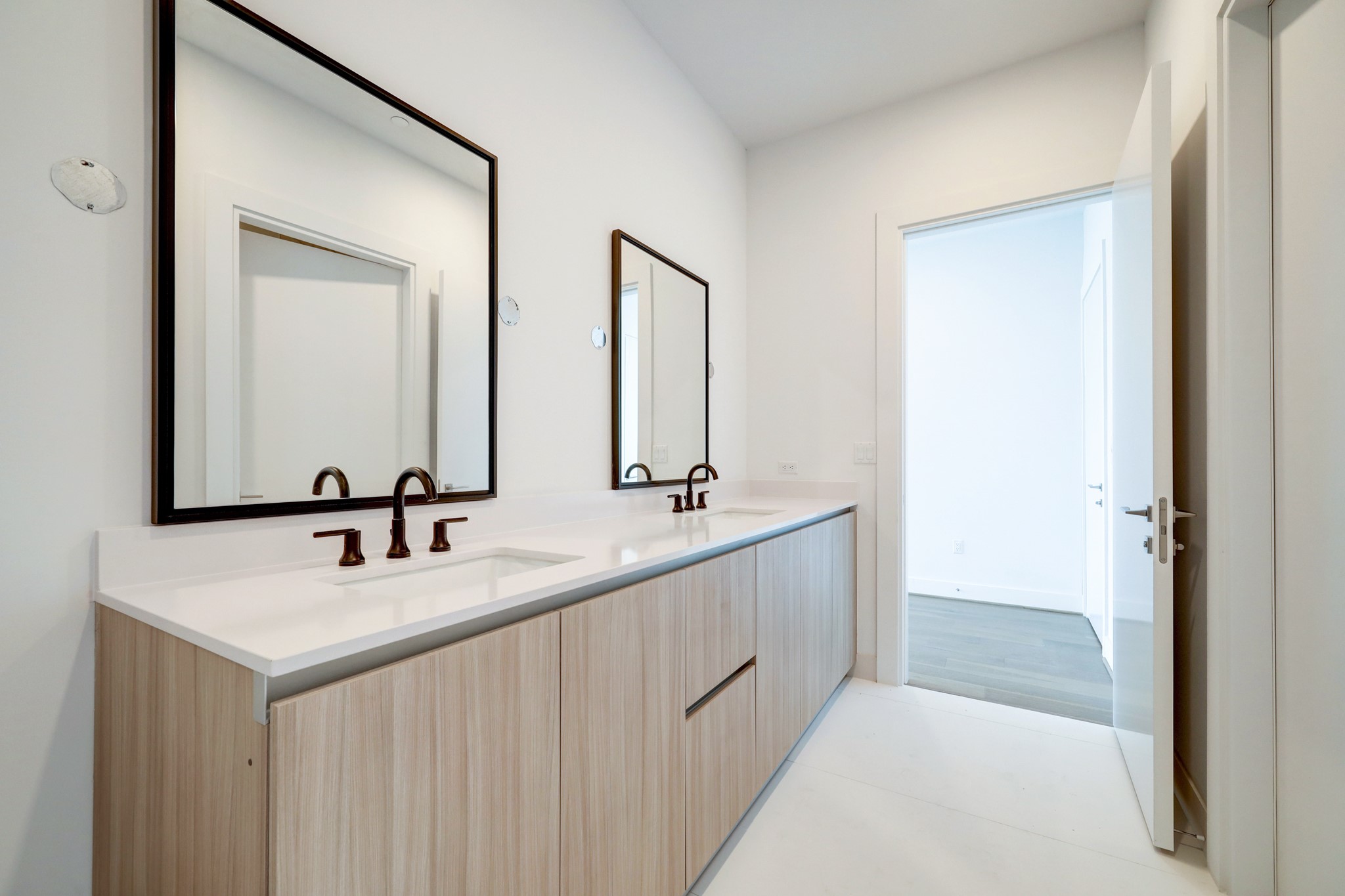 1711 Allen Parkway, Unit 2001 Houston, TX 77019 - Photo 6 of 33 This bathroom features a modern double vanity with sleek faucets, large mirrors, and ample storage space. The light Pedini cabinetry and quartz countertops create a bright, contemporary look.