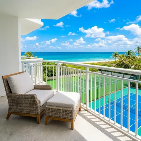 a view of a patio with lawn chairs and floor to ceiling window