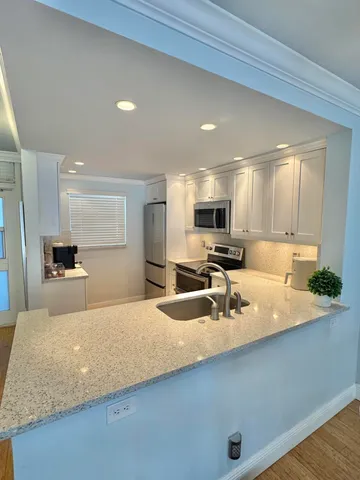 a large kitchen with kitchen island a sink stainless steel appliances and cabinets