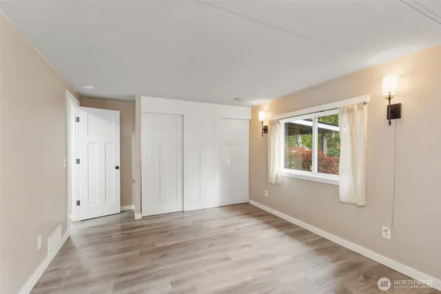 a view of a livingroom with wooden floor and windows