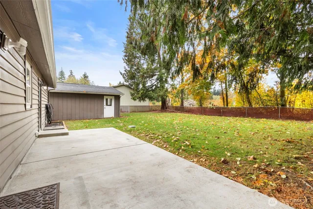 a view of backyard of house with green space