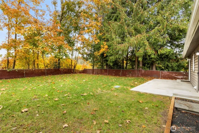 a view of yard with swimming pool and trees in the background