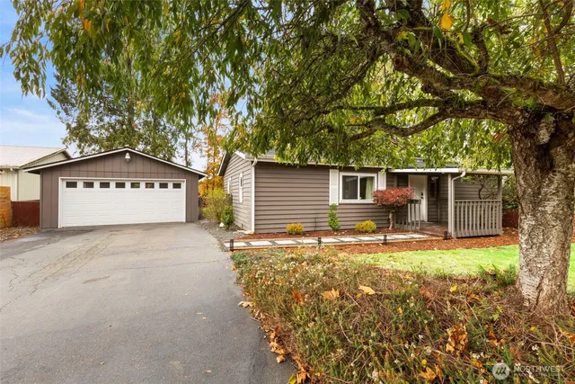 a view of a house with a large tree and wooden fence