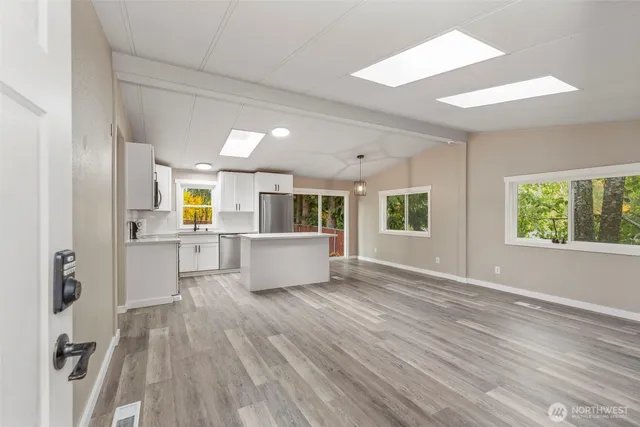 an empty room with wooden floor and windows