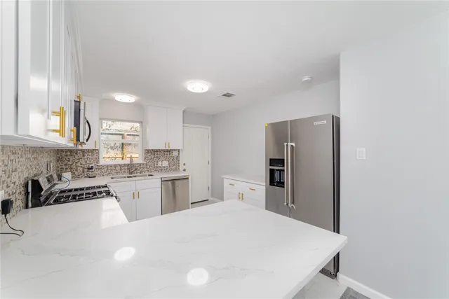 a kitchen with granite countertop cabinets stainless steel appliances and a sink