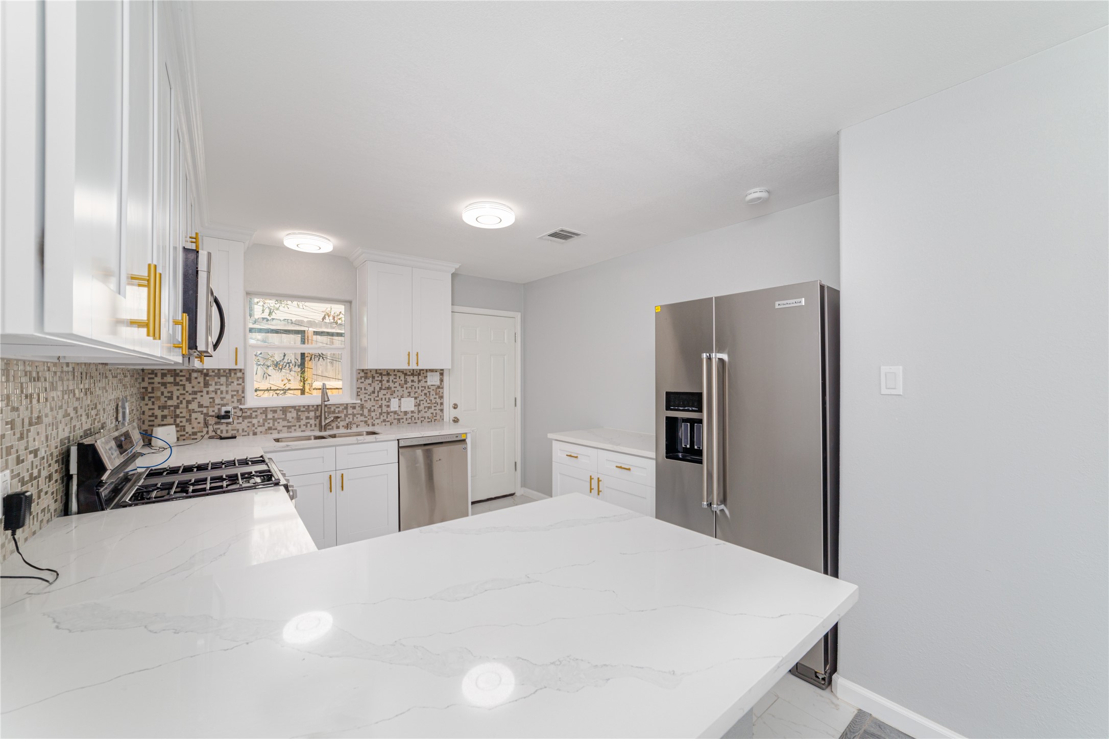 1716 Crestdale Drive, Unit 10 Houston, TX 77080 - Photo 12 of 21 a kitchen with stainless steel appliances granite countertop a refrigerator sink stove microwave and cabinets
