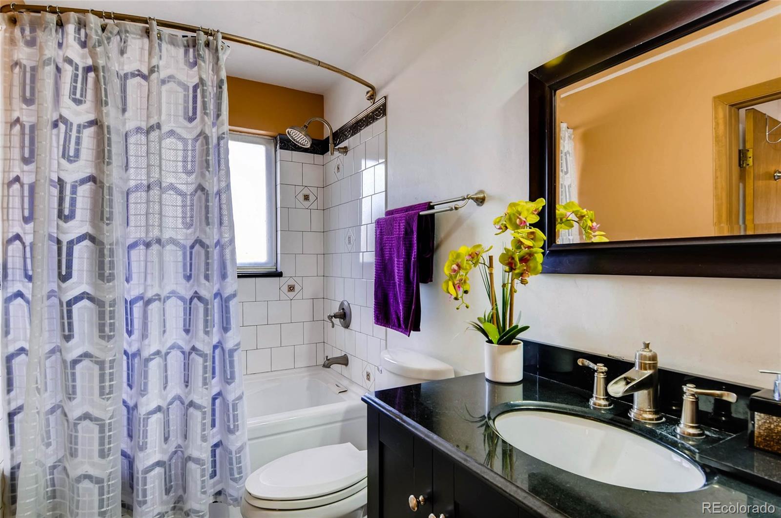 12475 West 38th Avenue Wheat Ridge, CO 80033 - Photo 13 of 22 a bathroom with a bathtub sink vanity mirror and toilet