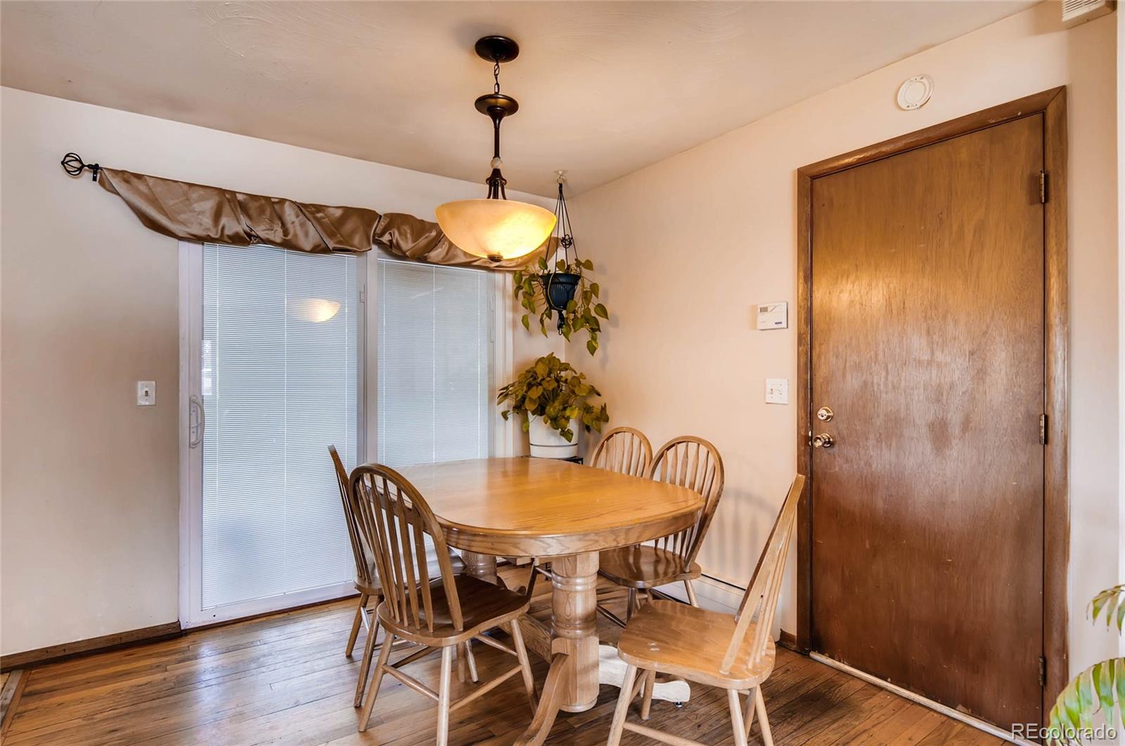 12475 West 38th Avenue Wheat Ridge, CO 80033 - Photo 7 of 22 a view of a dining room with furniture and wooden floor