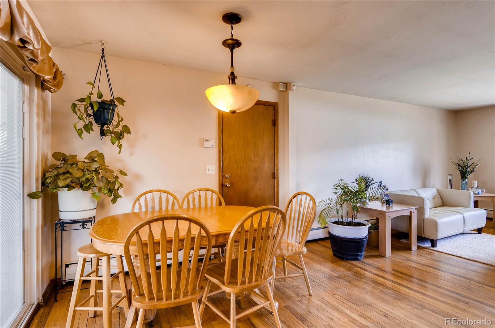 12475 West 38th Avenue Wheat Ridge, CO 80033 - Photo 8 of 22 a dining room with furniture potted plants and wooden floor