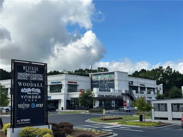 a front view of a building with street view and trees