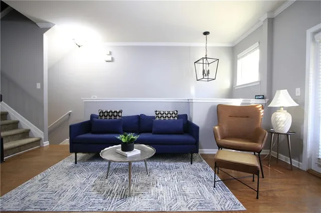 a living room with furniture and a dining room with wooden floor