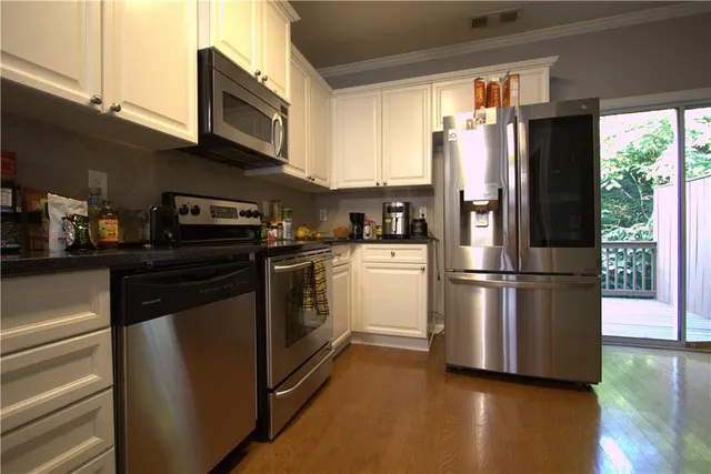 a kitchen with stainless steel appliances a refrigerator sink and microwave