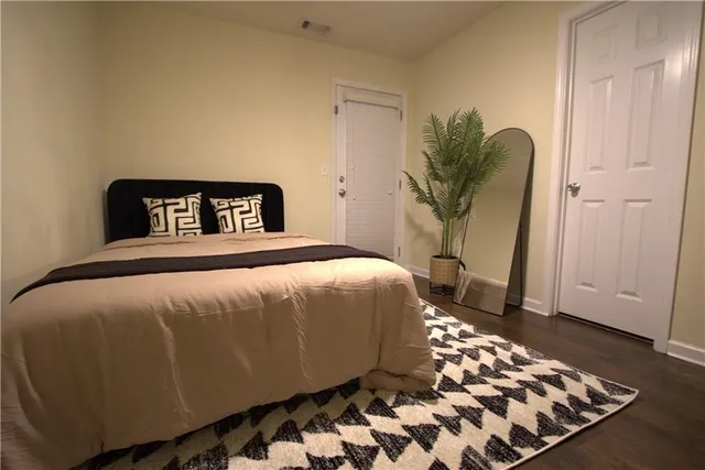 a bedroom with a bed and wooden floor