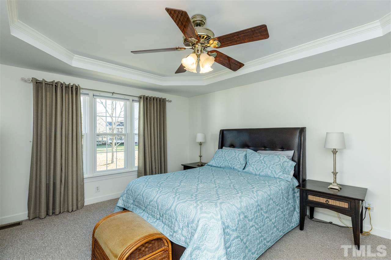 1016 Red Brick Road Garner, NC 27529 - Photo 13 of 29 a bedroom with a bed and a chandelier