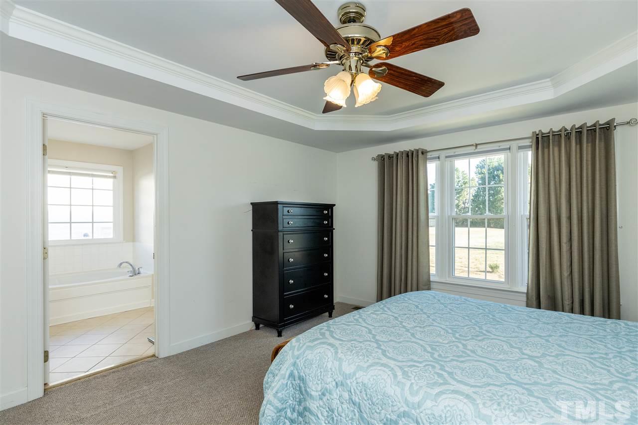 1016 Red Brick Road Garner, NC 27529 - Photo 14 of 29 a bedroom with a bed and a chandelier