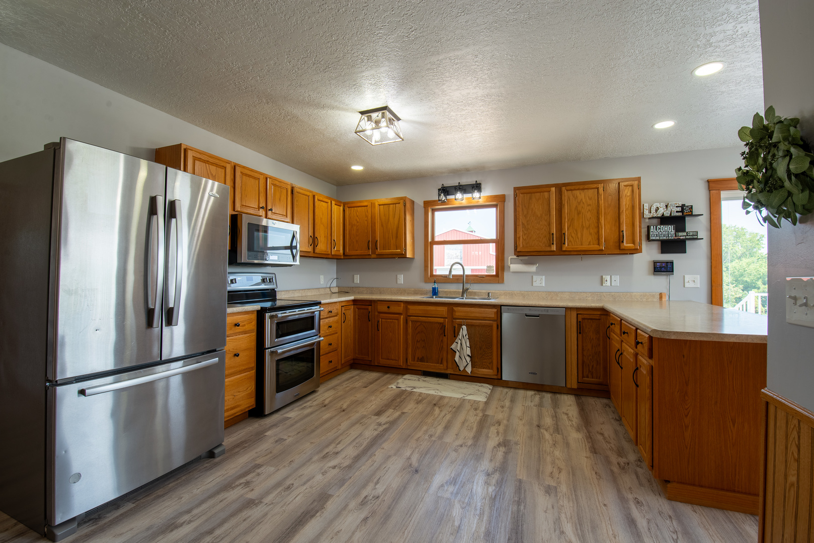 9109 Messmer Road Savanna, IL 61074 - Photo 5 of 31 a kitchen with stainless steel appliances granite countertop a refrigerator a stove top oven a sink dishwasher and wooden floor
