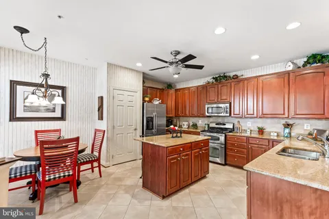 a kitchen that has a lot of cabinets in it and stainless steel appliances