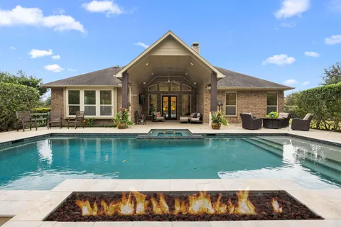 a front view of a house with swimming pool and a yard