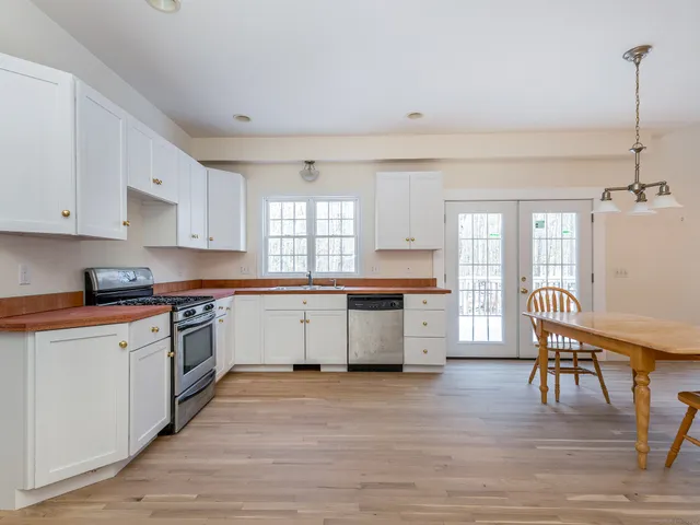 a kitchen with a white cabinets and wooden floor