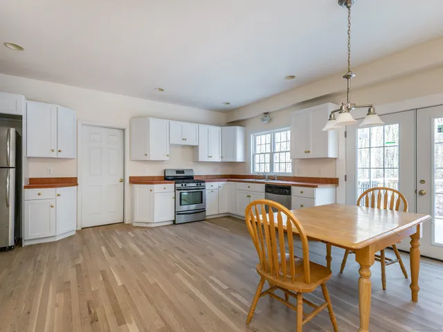 a kitchen with stainless steel appliances granite countertop a white cabinets and wooden floor