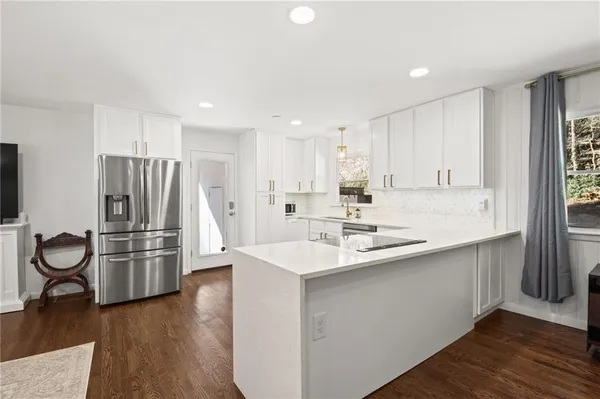 a kitchen with stainless steel appliances granite countertop a refrigerator sink and stove