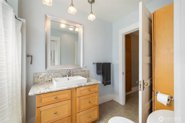 a bathroom with a granite countertop sink and a mirror