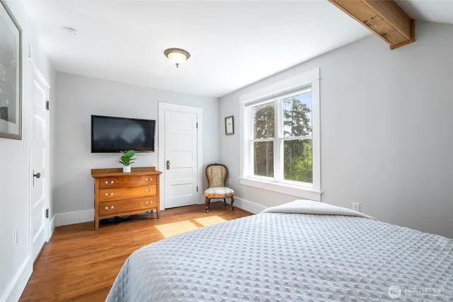 a bedroom with furniture window and flat screen tv