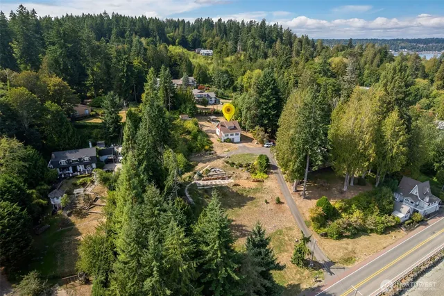 an aerial view of residential house with outdoor space and trees all around