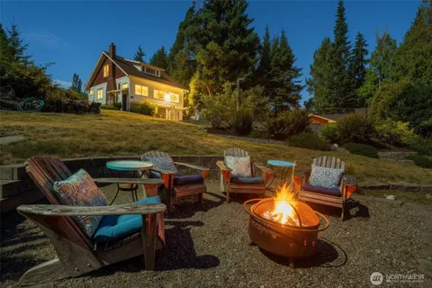 a view of a patio with table and chairs with plants and trees